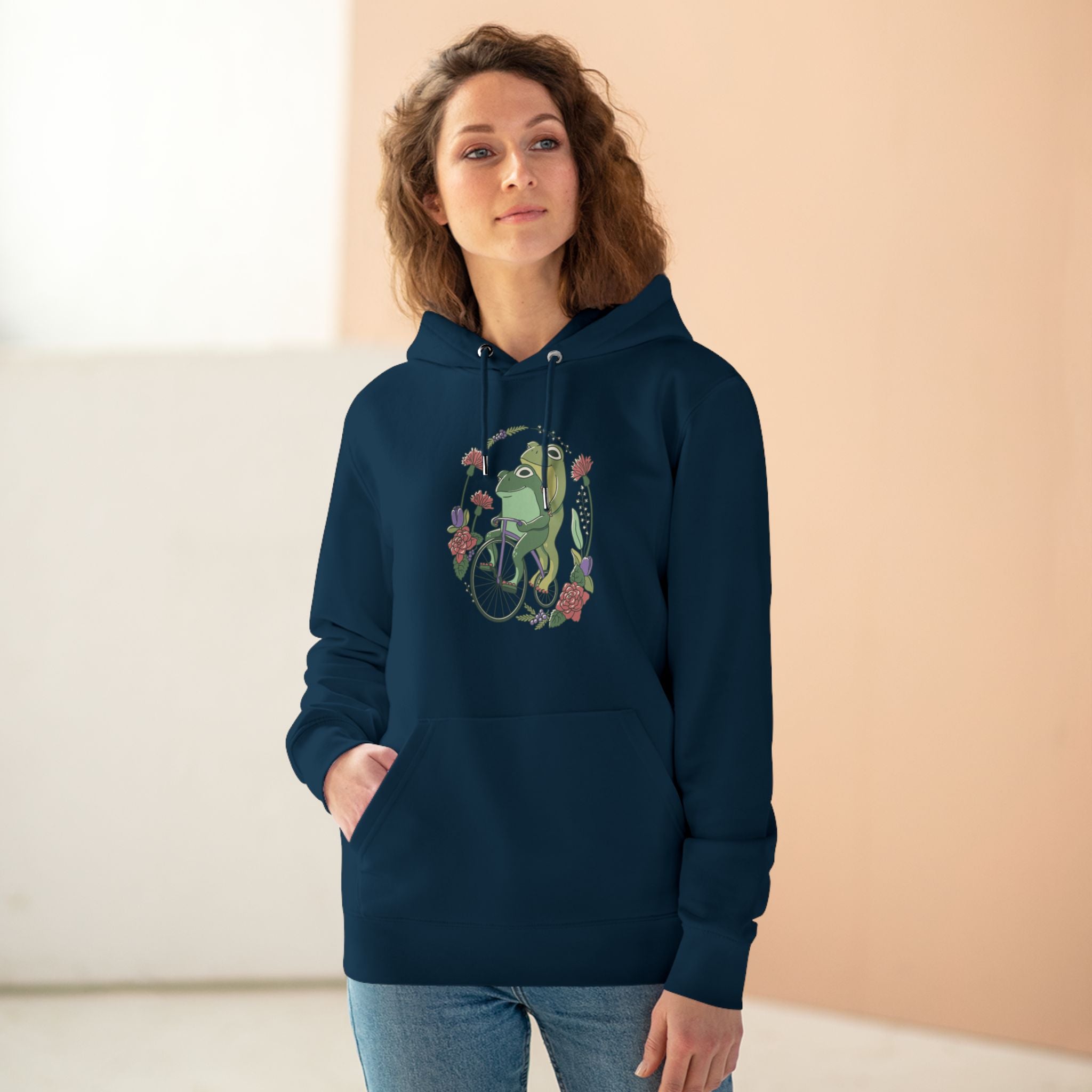 Cottagecore Unisex Hoodie Stil mit fröhlichen Fröschen auf Fahrrad